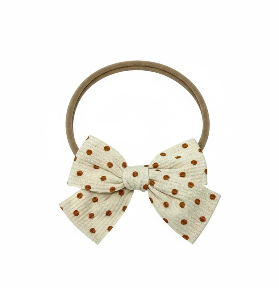 Fabric orange brown polka dot bow on a headband