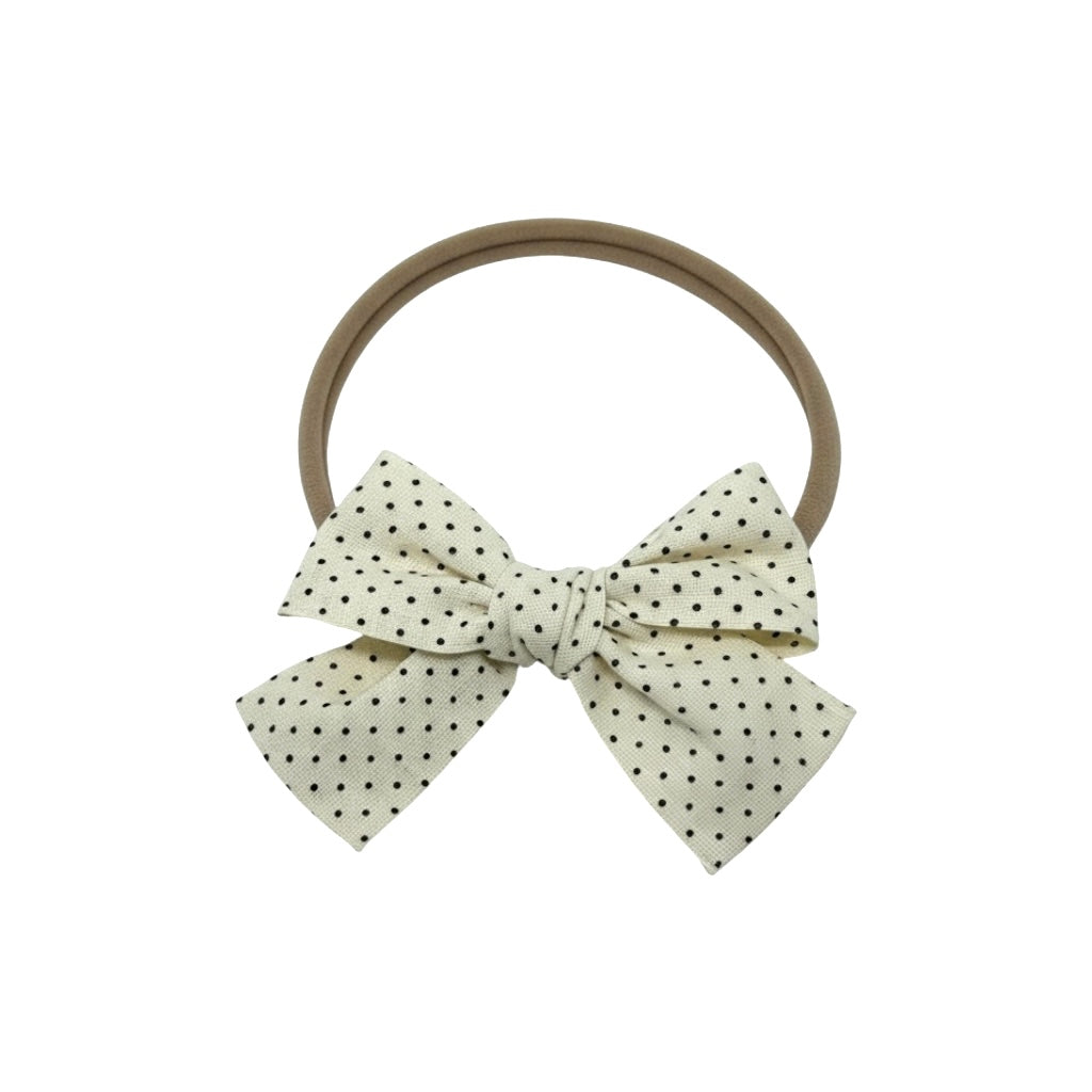 Small polka dot fabric bow on a headband